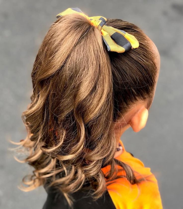 little girl  with a cute high ponytail with a a cute bow