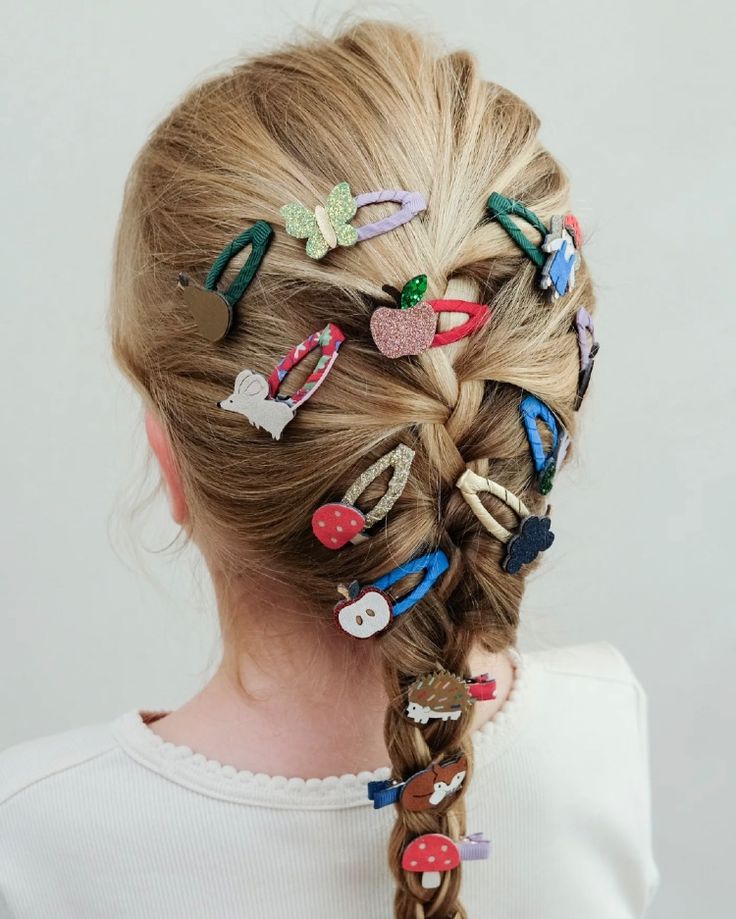 A braided hairstyle decorated with dozens of small clips and charms, illustrating how much accessory weight hair can carry