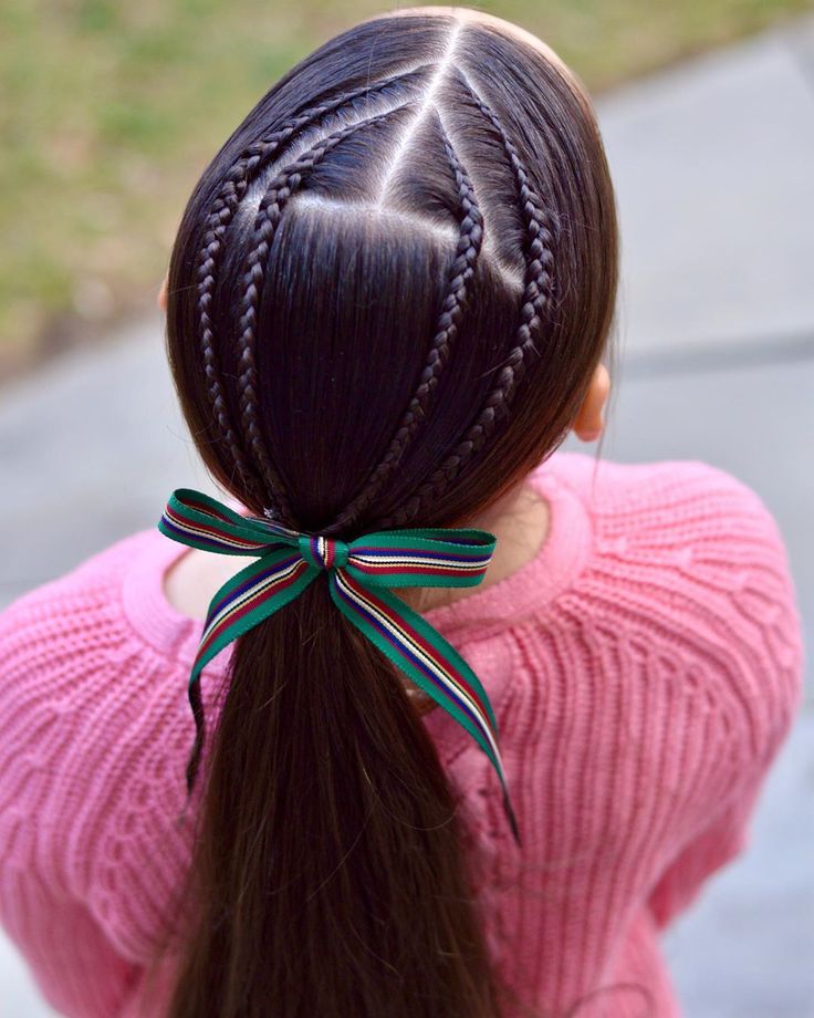 Ponytail with two lace braids framing the face and a bow accent