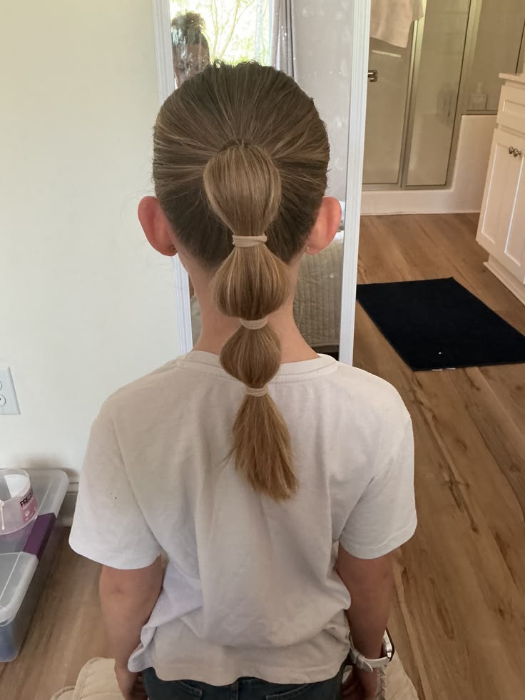 Kid's bubble ponytail with rounded sections created using small elastic bands
Short: bubble ponytail for kids