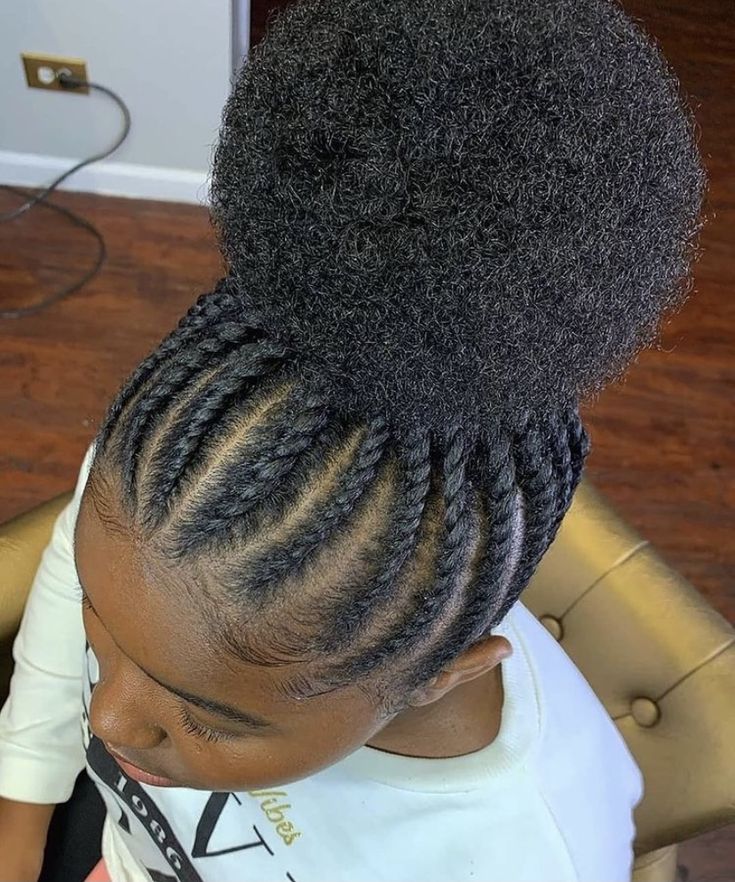 Child wearing flat twists close to the scalp, gathered into a curly puff at the crown