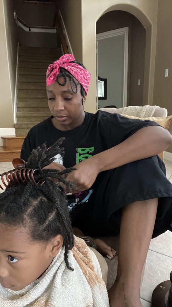 A parent removing a child's protective twist style, sectioning through the twists by hand