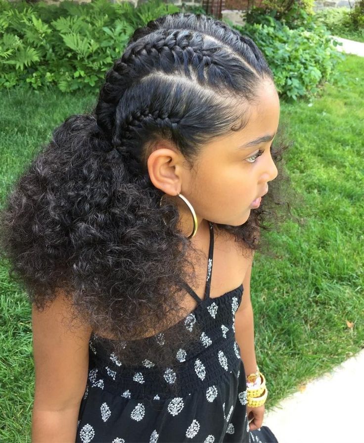 Child with French braid cornrows feeding into curly hair
