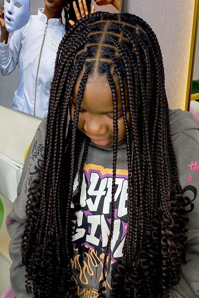 Child with box braids and curly ends