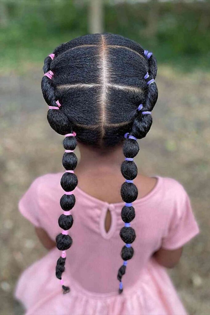 Cute layed down double bubble hairstyles. With colourful bands