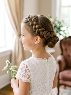 A cute young girl with a bun with side braids
