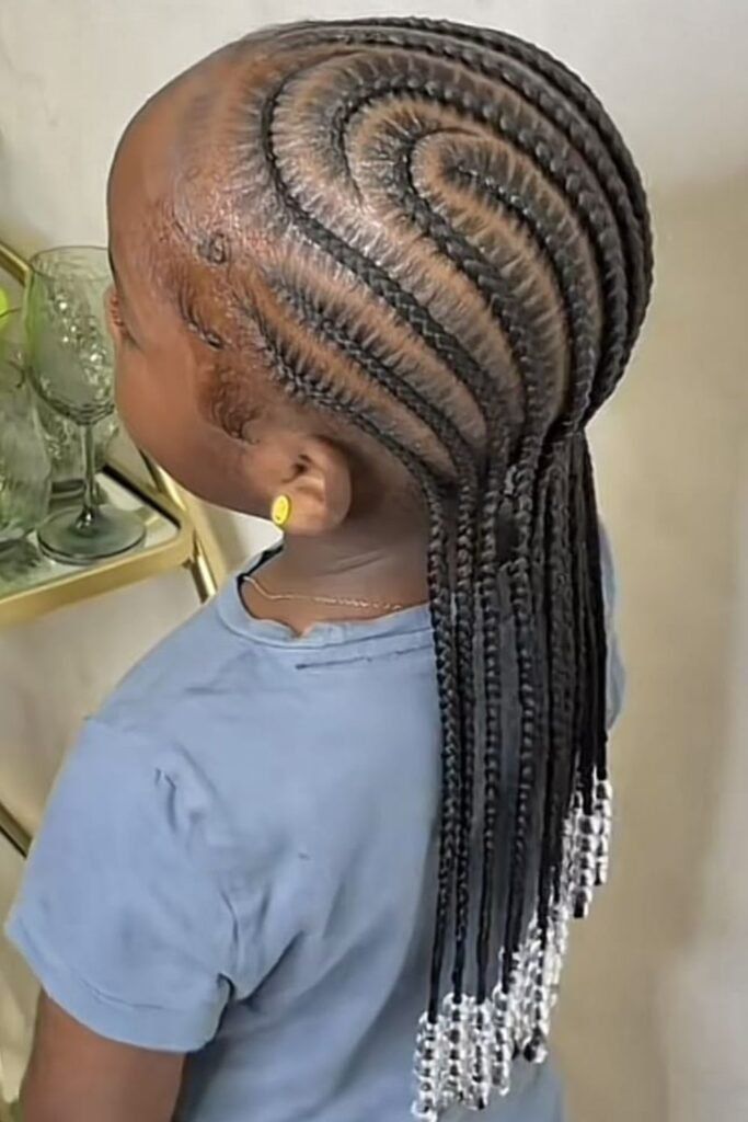 A young black girl with a curved cornrow