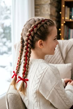 Young girl with a cute red ribbon wrapped braids.