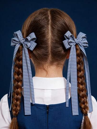 Child with two neat ponytails secured with checked ribbon