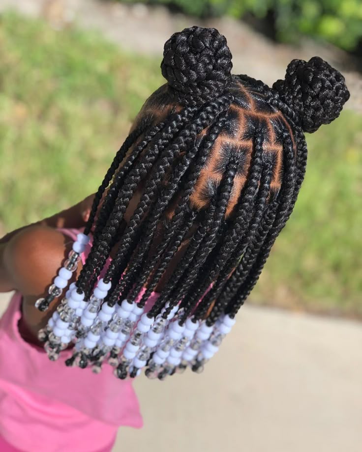 Double bun knotless braids for kids with two braided buns and white beads