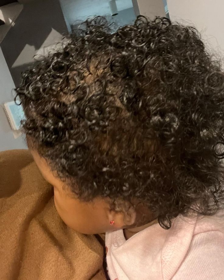 little baby with a curly head of hair