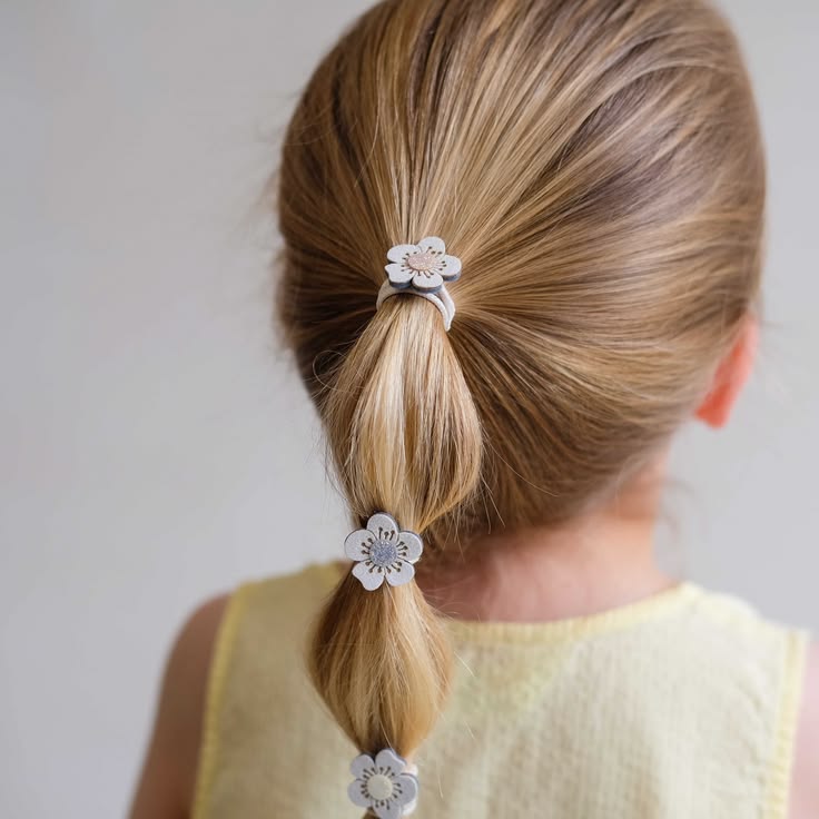 young girl with a bubble ponytail accessorized with jeweled hairtie