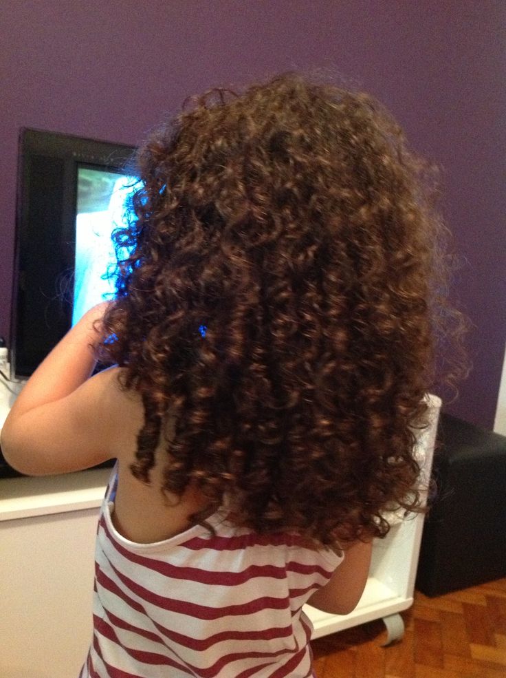 A toddler with a long, thick and 
 brown curly hair 