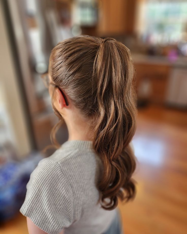 A young white girl with a classic high ponytail with curly hair