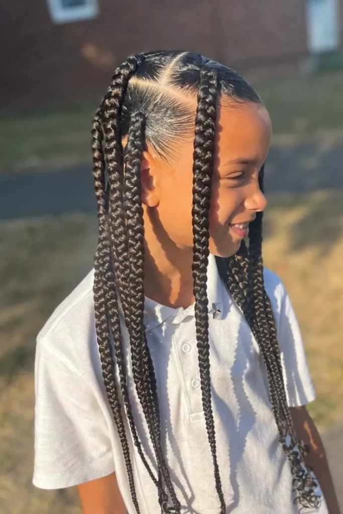 A child wears large jumbo box braids parted with visible sections, framing the face on each side.