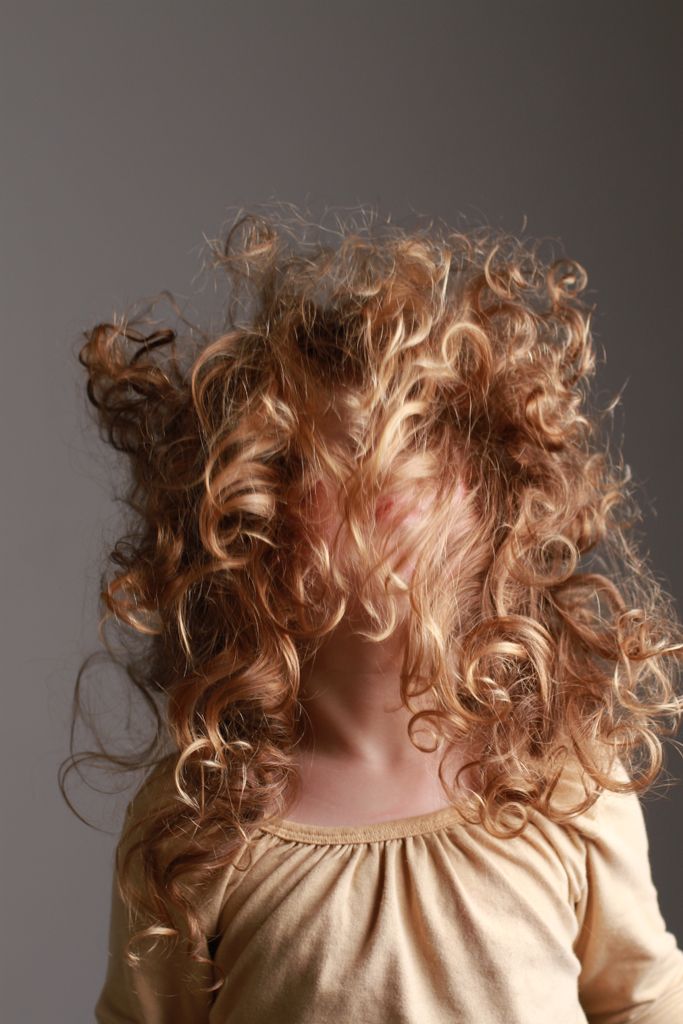 Child with large, tangled curly hair showing signs of dryness and lack of care