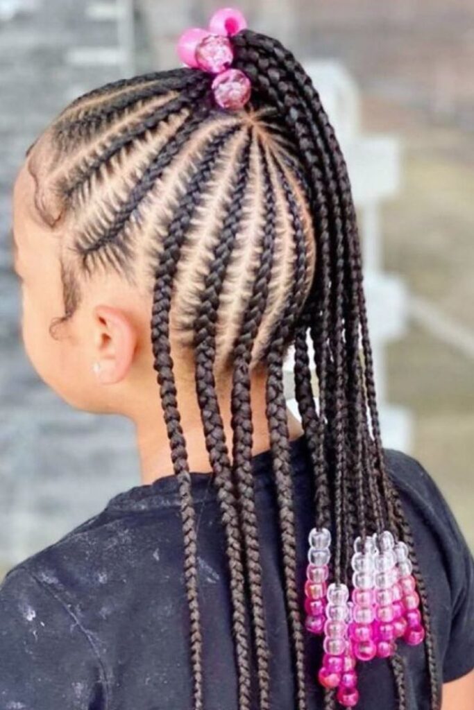 Little girl with feed in braids adored with colorful pink beads