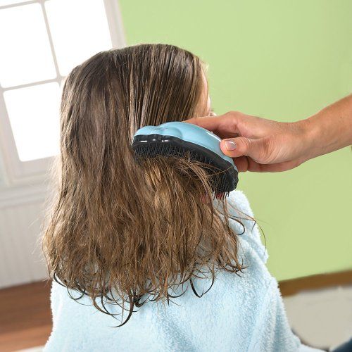 A hand brushing a a little girls type 2 hair with a detangling brush