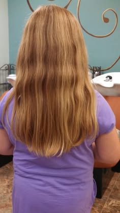 Back view of a girl with long type 2A hair, straight through most of its length with soft, subtle waves near the ends.