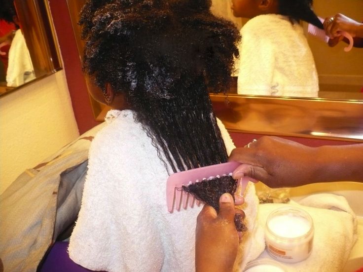A hand detangling a well moisturized type 4 hair hair