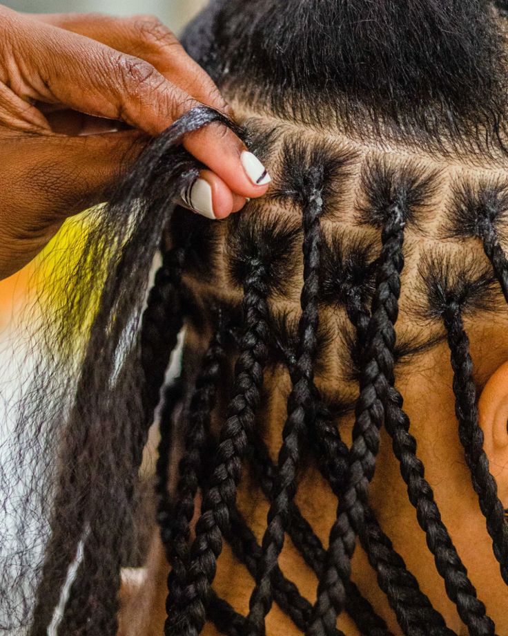 A hand adding extension to a chids hair