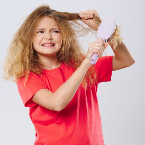 Child brushing dry frizzy hair