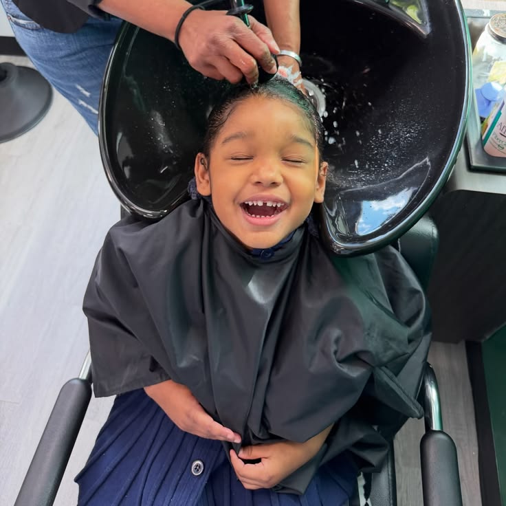 Child getting hair washed at salon before styling