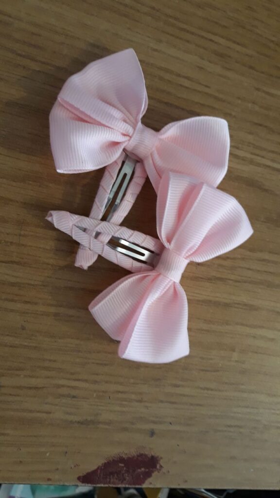Two piece of baby pink clip on bows