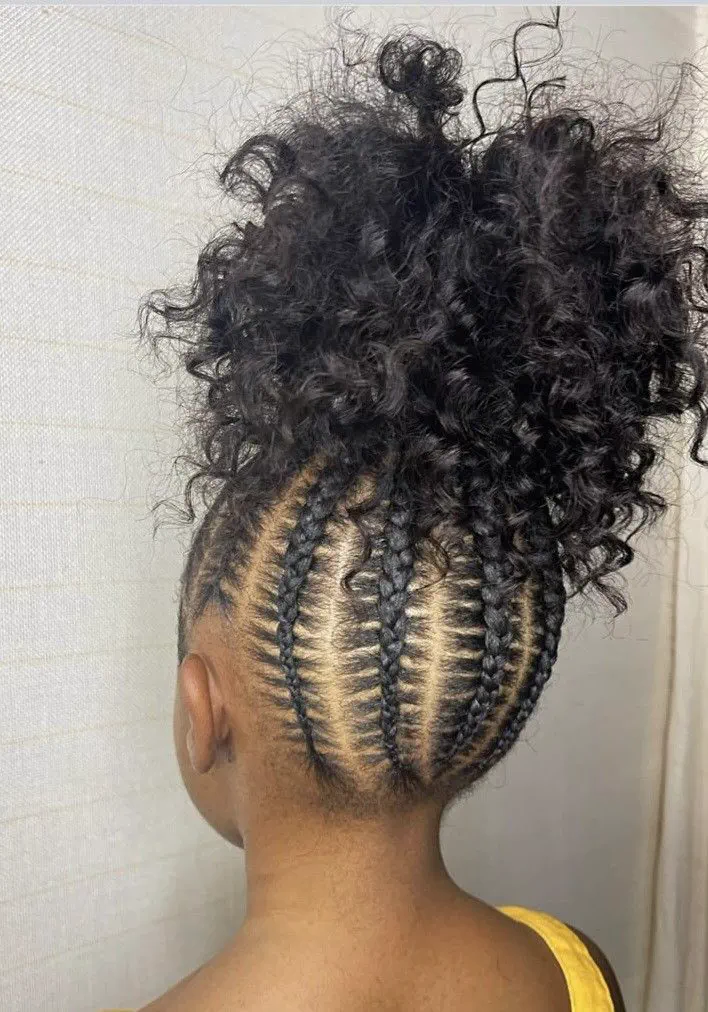 Young black girl with a curly ponytail wit a cornrow base