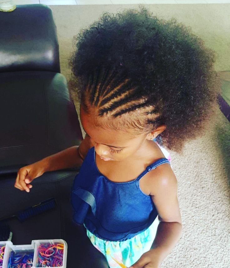 A child's hair is styled with cornrows across the top section, while the remaining length stays loose and curly, creating a half-up look.