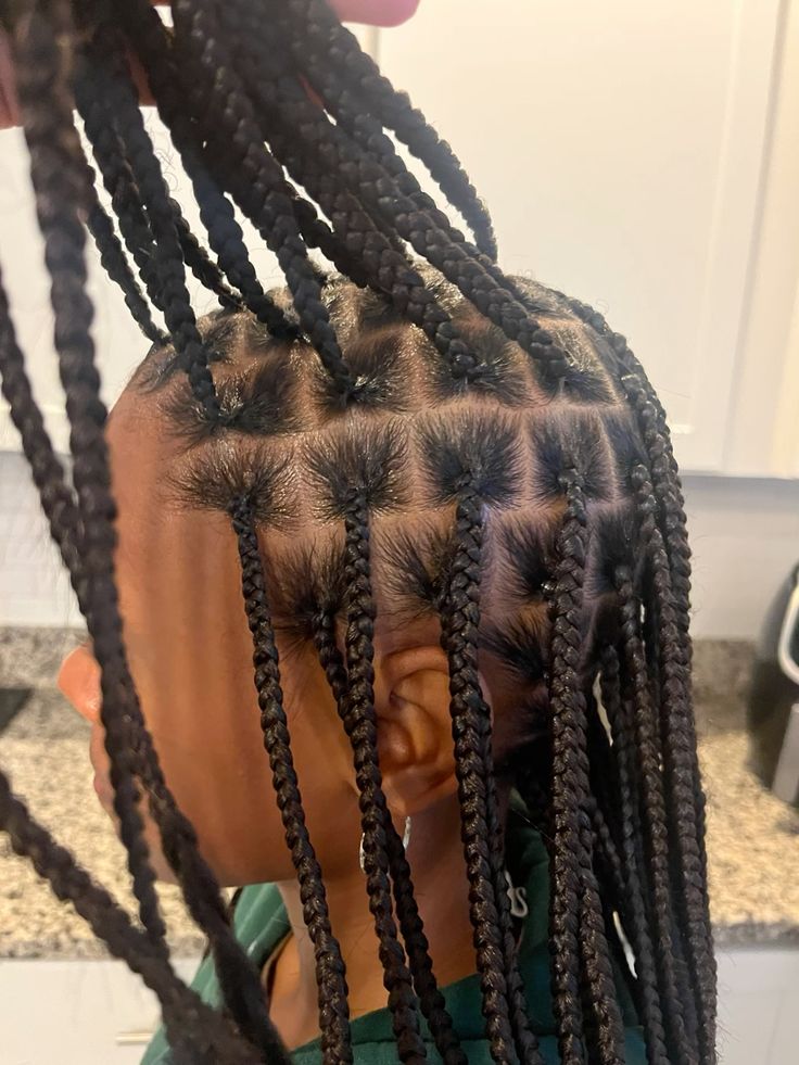 Kid wearing classic knotless braids with neat  parts .