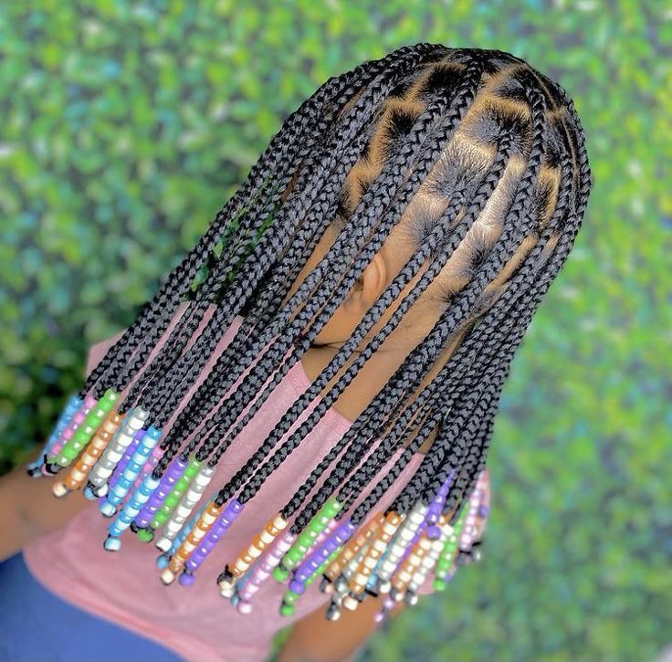 Young girl with knotless braids featuring colorful beads on the ends.