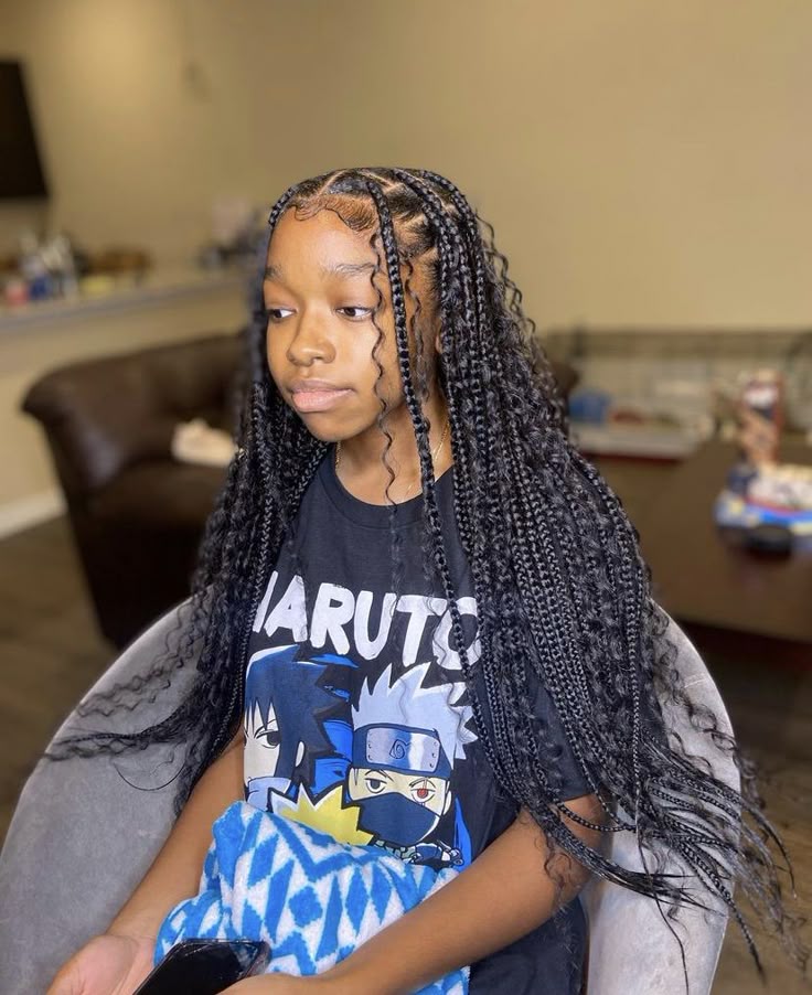Boho knotless braids for kids with loose curly strands throughout the hairstyle.
