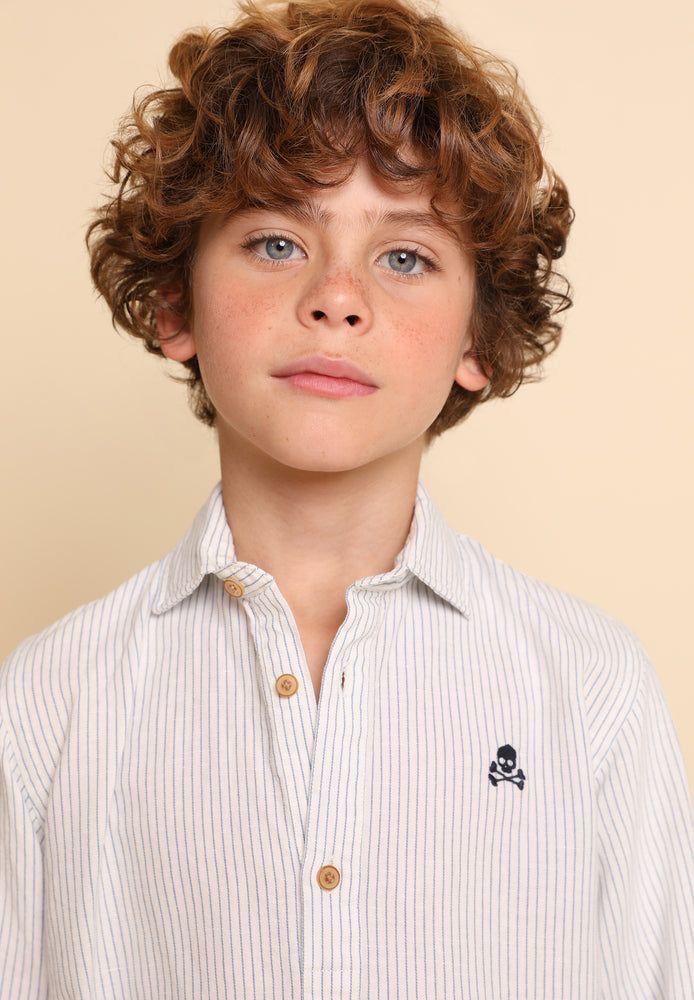 Boy with a curly fringe hairstyle, full loose curls left long over the forehead framing the face.
