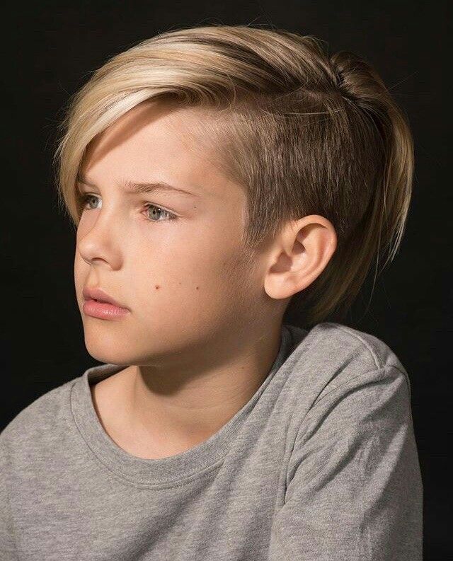 Boy with a disconnected undercut, long swept top hair with a hard line drop to very short buzzed sides.