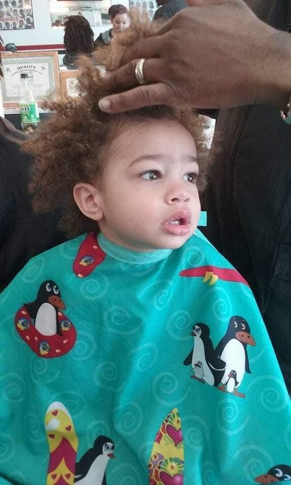child getting coily hair trimmed