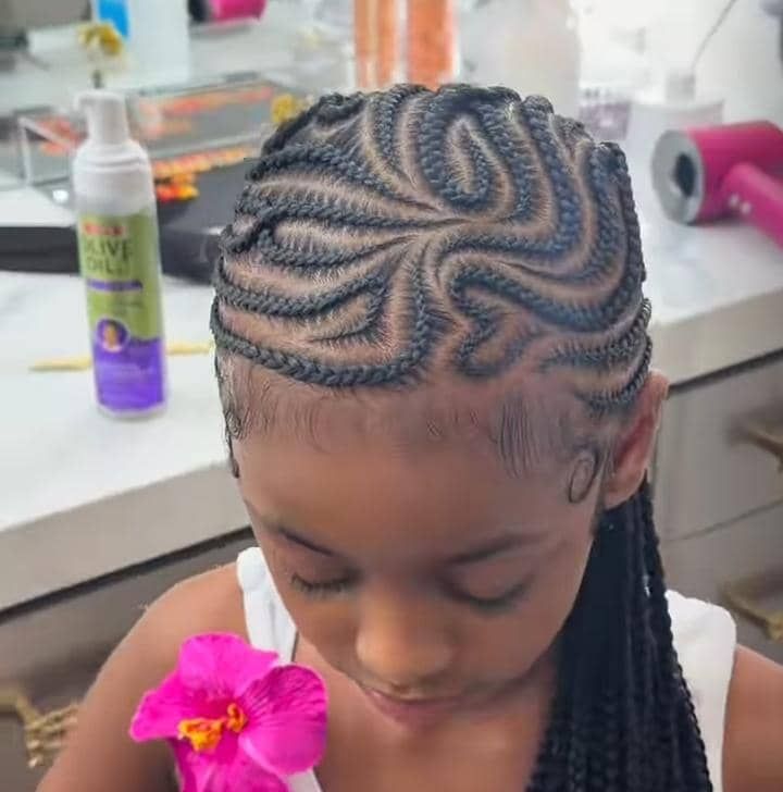 Little girl wearing swirl feed in braids with a spiral braid pattern.