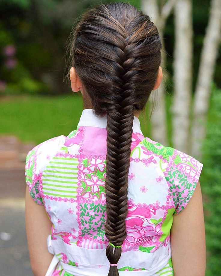 a young girl with her back facing the camera show her cute long fish tail hairstyle