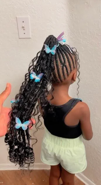 Young girl with a cute long feed in braided ponytails with butterfly clips
