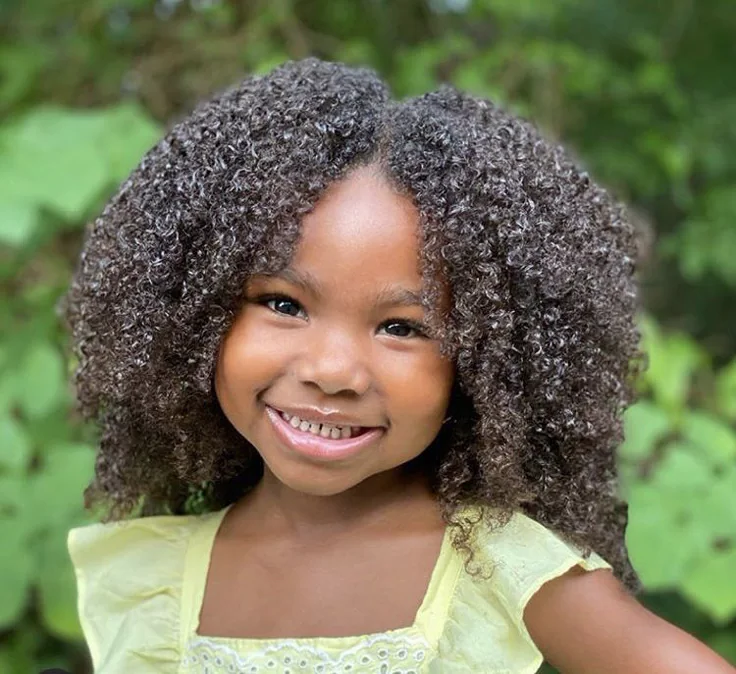 A cute young girl with a full black coily hair
