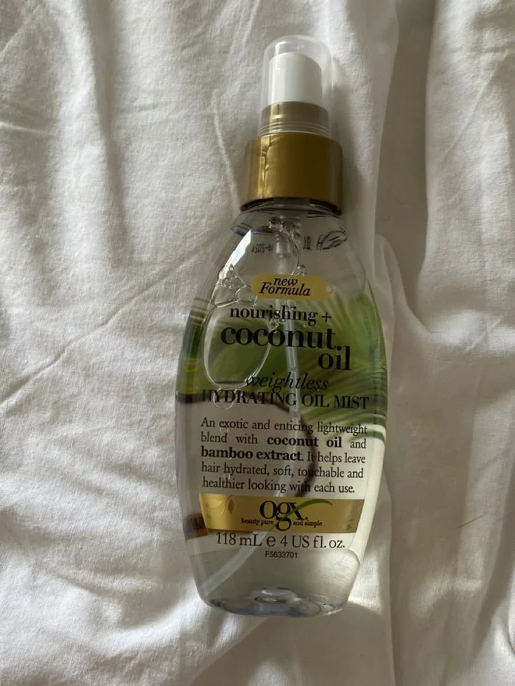 Bottle of weightless coconut oil hydrating mist, used to seal in moisture and add shine to natural curly hair.