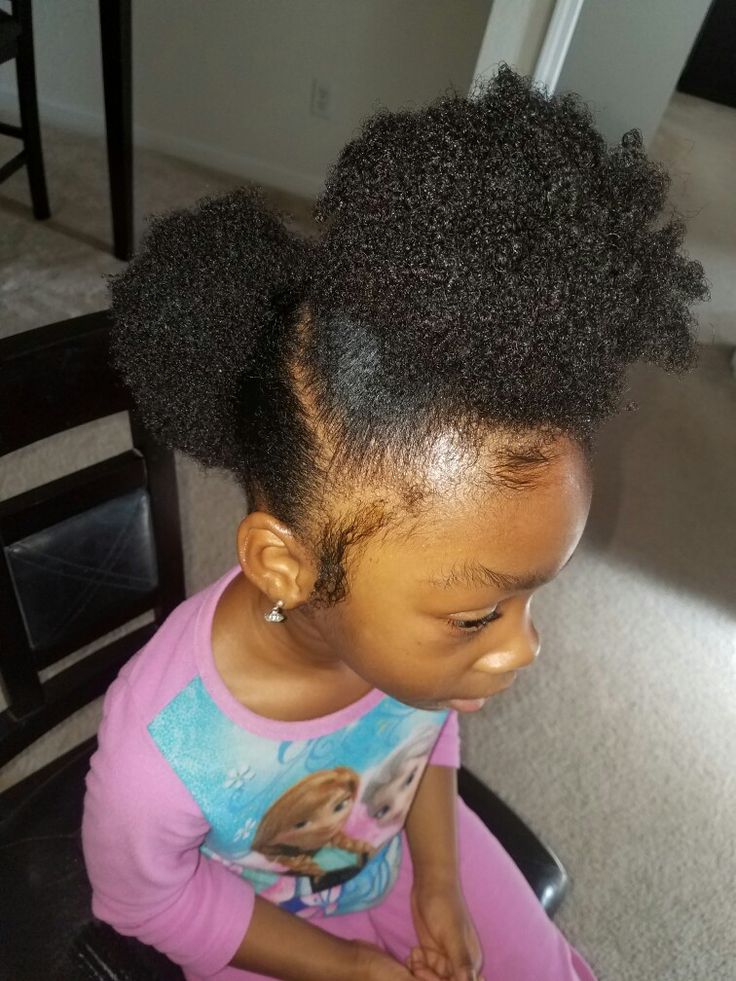 Girl with natural hair styled in a high curly puff.