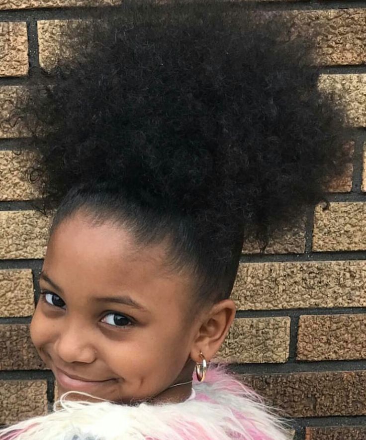 Young girl with 4C hair styled in a full high puff at the crown