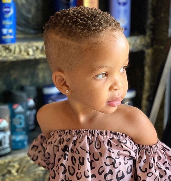 Toddler's first haircut styled as a short curly fade.