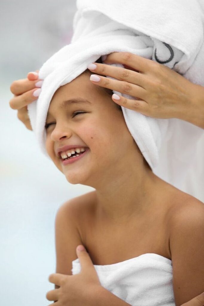 Gently drying child's hair with a towel