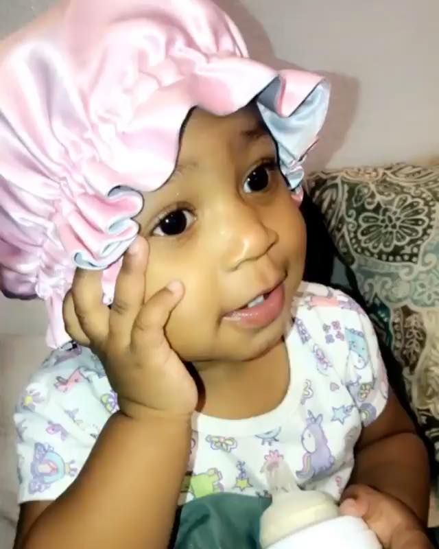 Little toddler wearing a satin bonnet ready to sleep