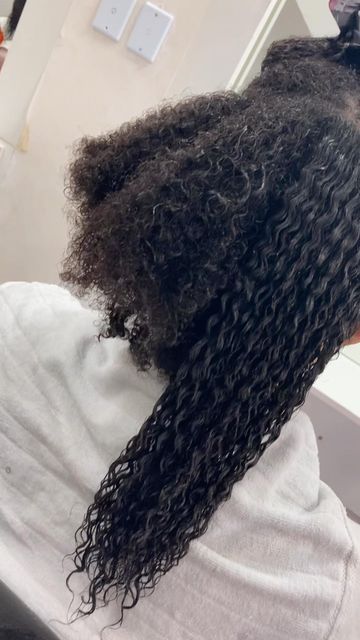 Long, defined natural curls resting on shoulders, showing soft and well-moisturized curl pattern from root to end.