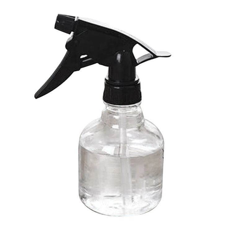 Clear spray bottle filled with water, used as a first step to add moisture before applying leave-in conditioner to kids' hair.