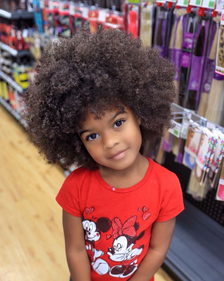 Child with full, fluffy 4B curls showing a zigzag pattern