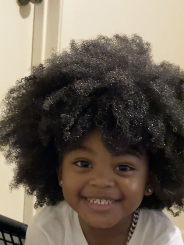 Child with dense, tightly coiled 4C curls and a full afro shape